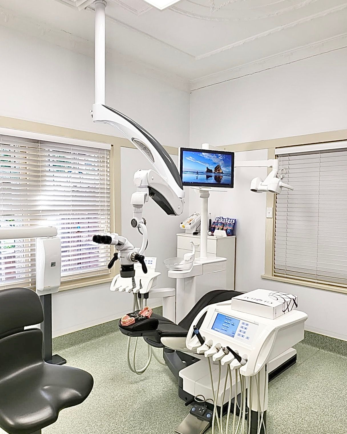 A dental office with a dental chair and a microscope.