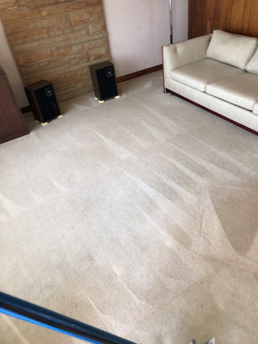 A living room with a white couch and speakers