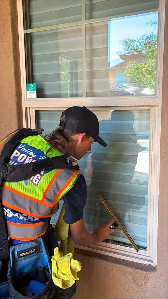 Valley Pro Power Wash technician cleaning exterior windows at Vantage Condos in Ahwatukee Arizona