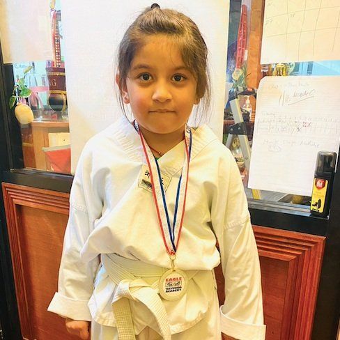 A person is holding a sparkler in their hand in the dark.