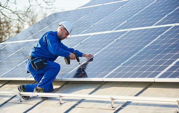 a man working on a solar panel on a roof