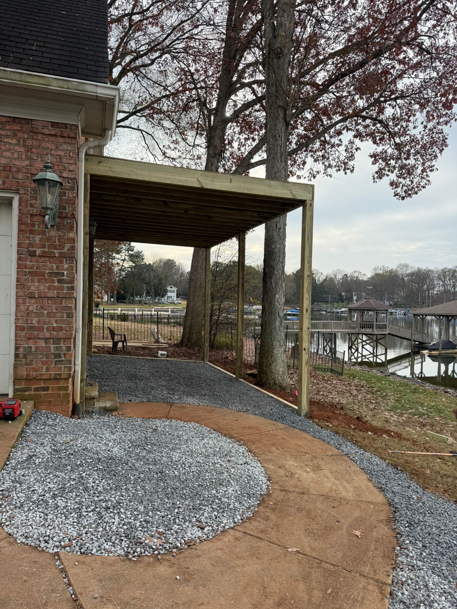 Cleared patch of land with brown dirt and trees, bright sun in the sky.