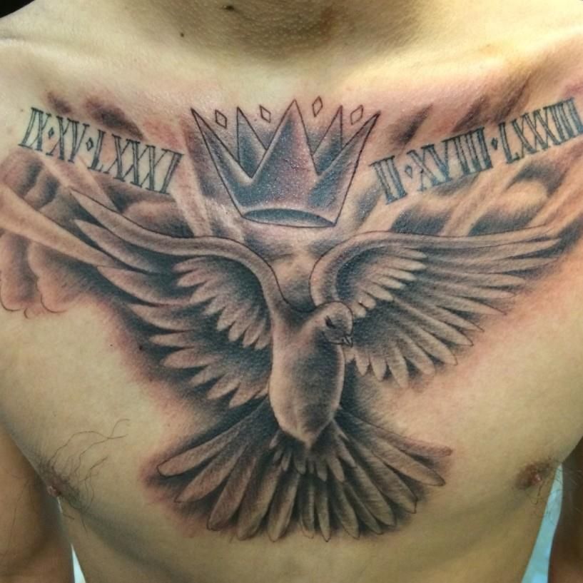 Tattoo on chest featuring a dove with outstretched wings, a crown, and roman numerals in gray.