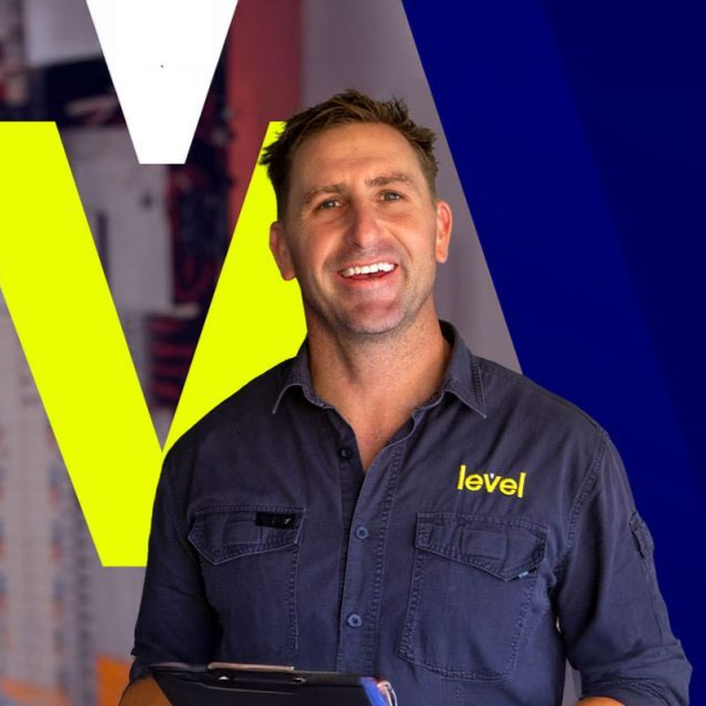 Two people stand beside plumbing trucks, logo 