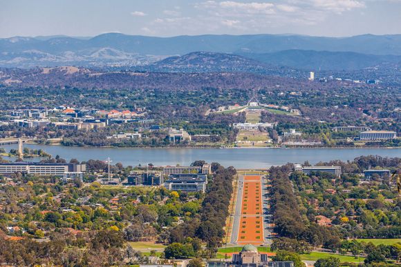 Aerial view of Canberra, Australia, with Lake Burley Griffin and Parliament House visible.