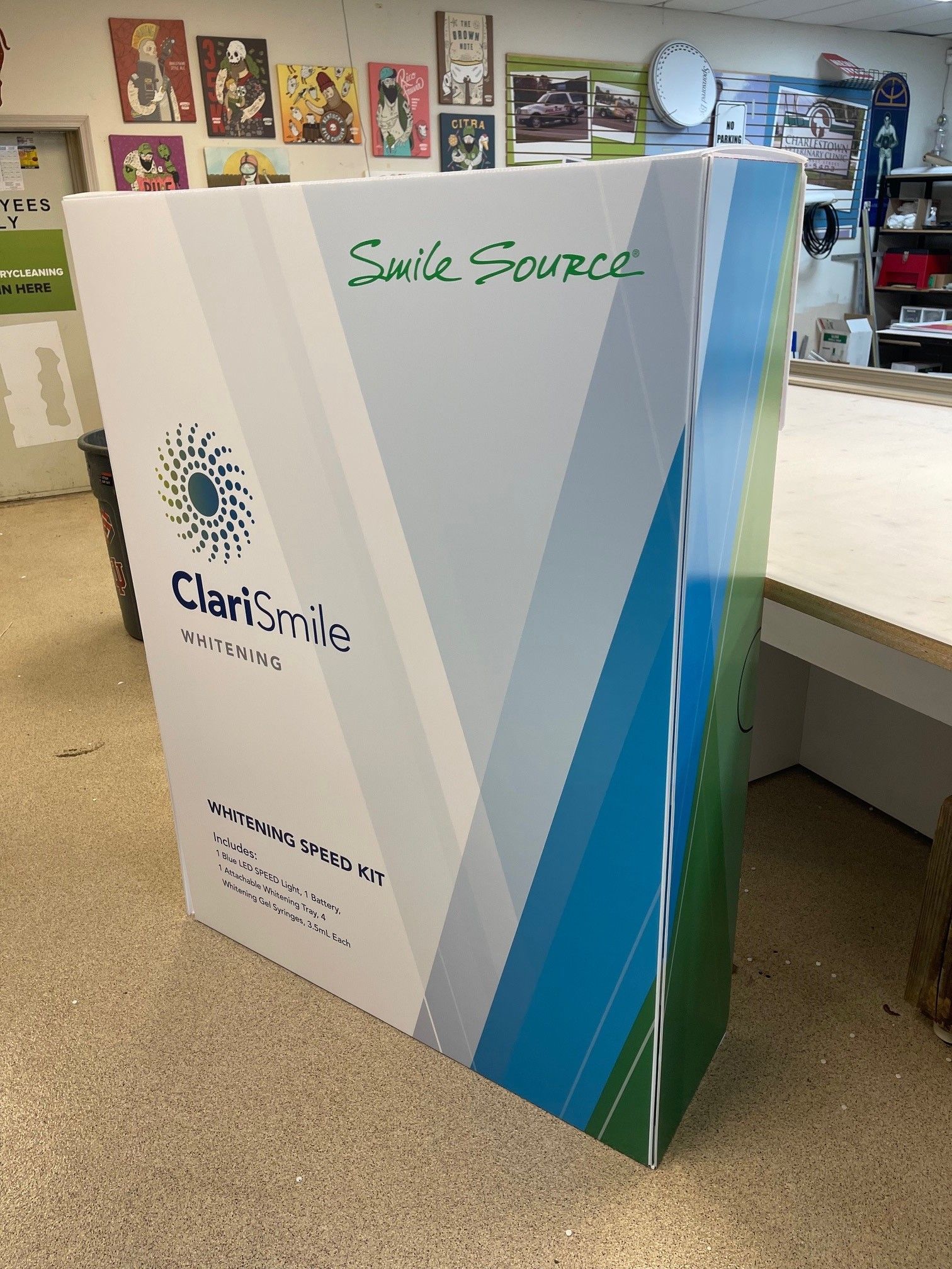 A large white box with a blue and green logo on it is sitting on the floor.