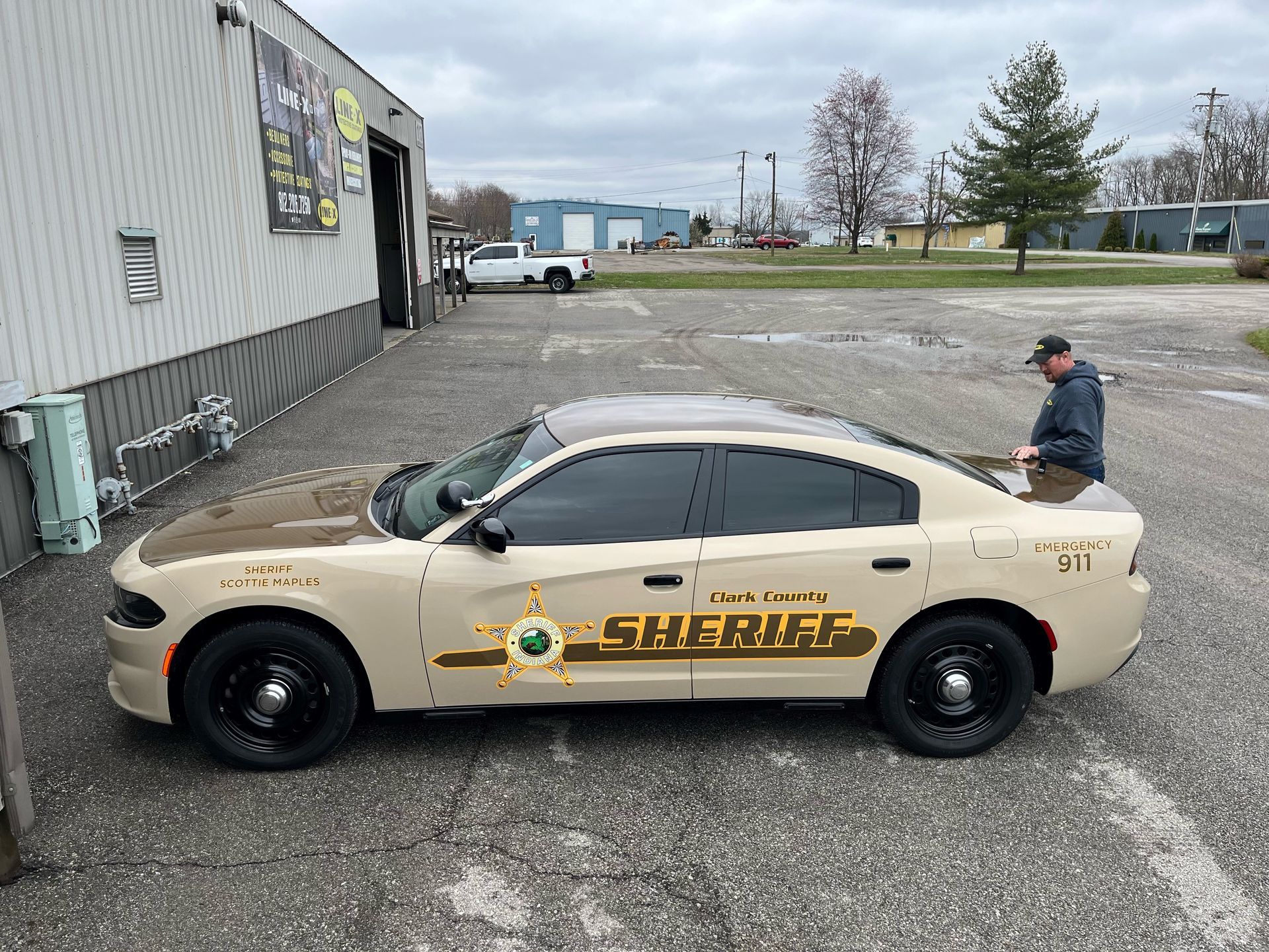 A sheriff 's car is parked in a parking lot next to a building.