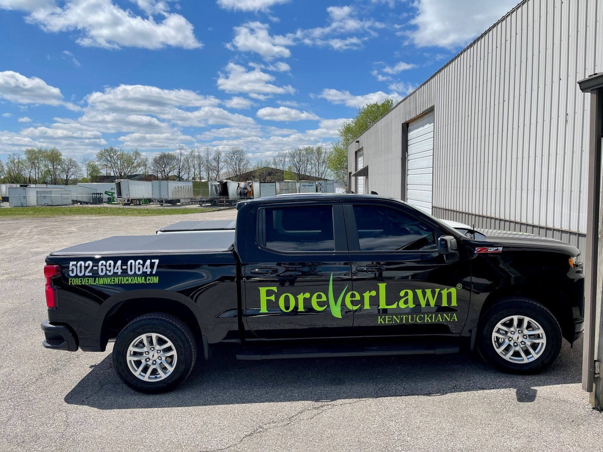 A black truck is parked in front of a building.