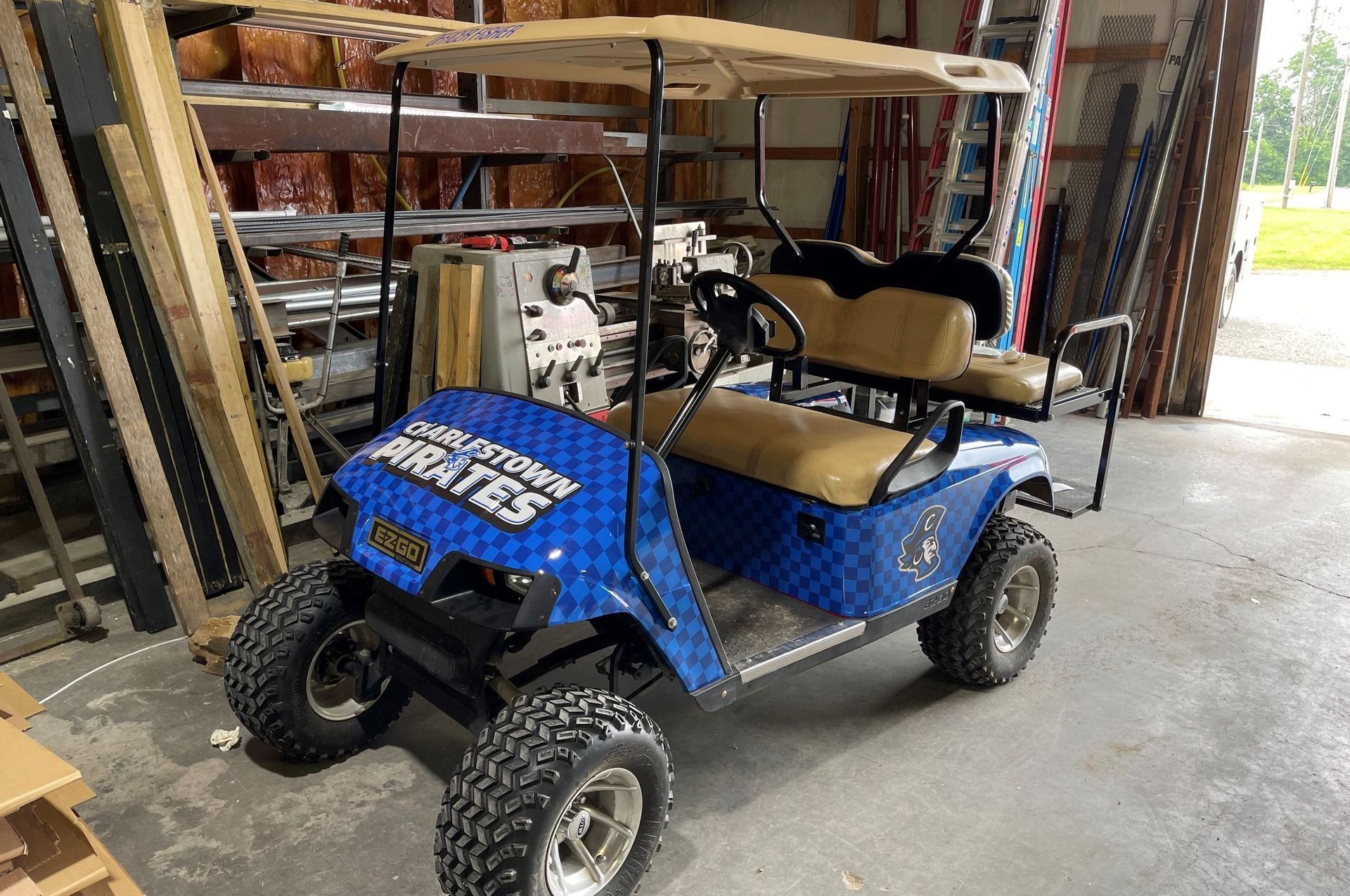 A blue golf cart is parked in a garage.