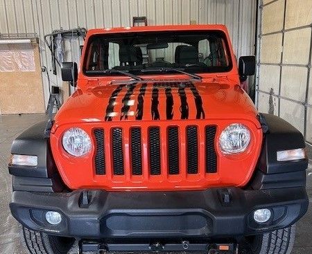 A red jeep wrangler is parked in a garage.