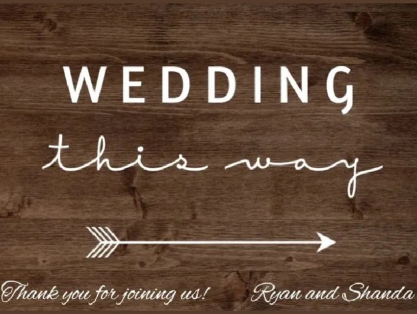 A wooden sign that says wedding this way