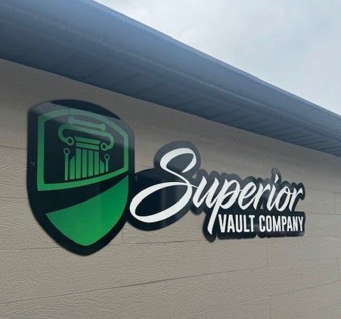 A sign for superior vault company is on the side of a building.