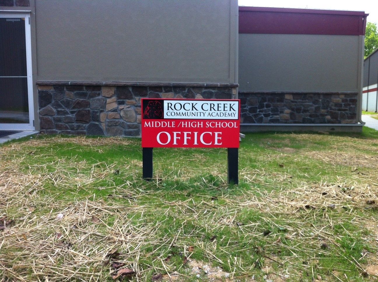 A red sign that says rock creek middle school office