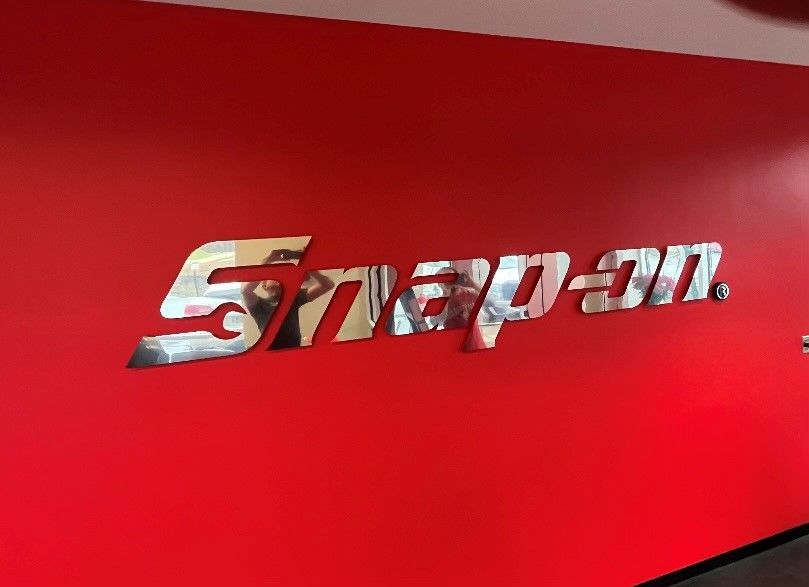 A red wall with a snap on sign on it