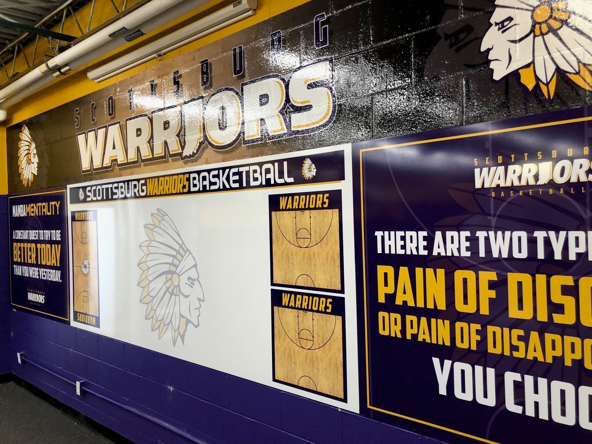 A warriors basketball sign is hanging on a wall