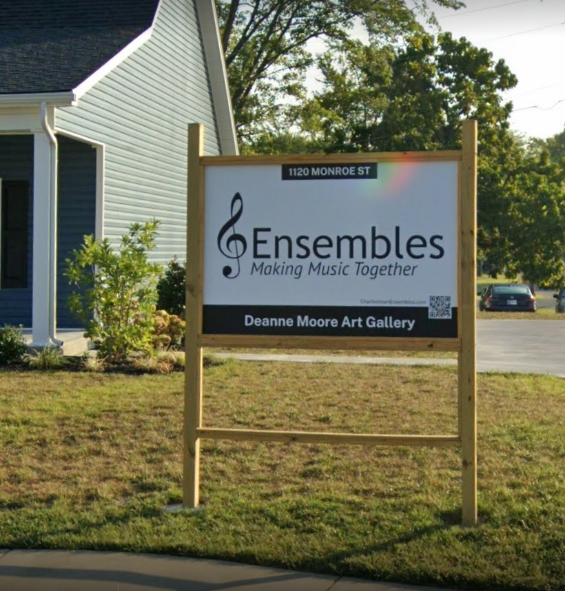 A sign for ensembles making music together in front of a house