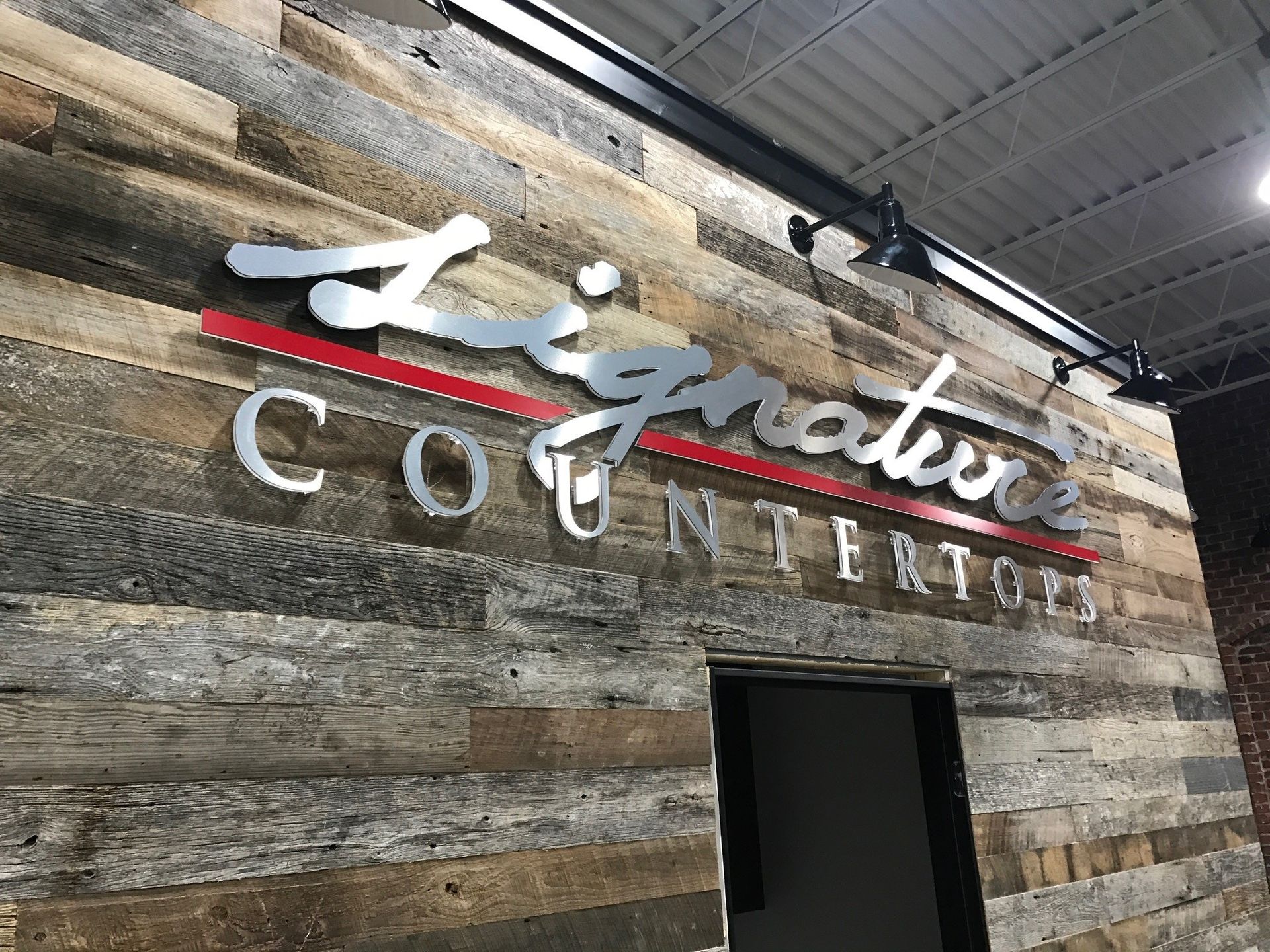 A sign on a wooden wall that says signature countertops