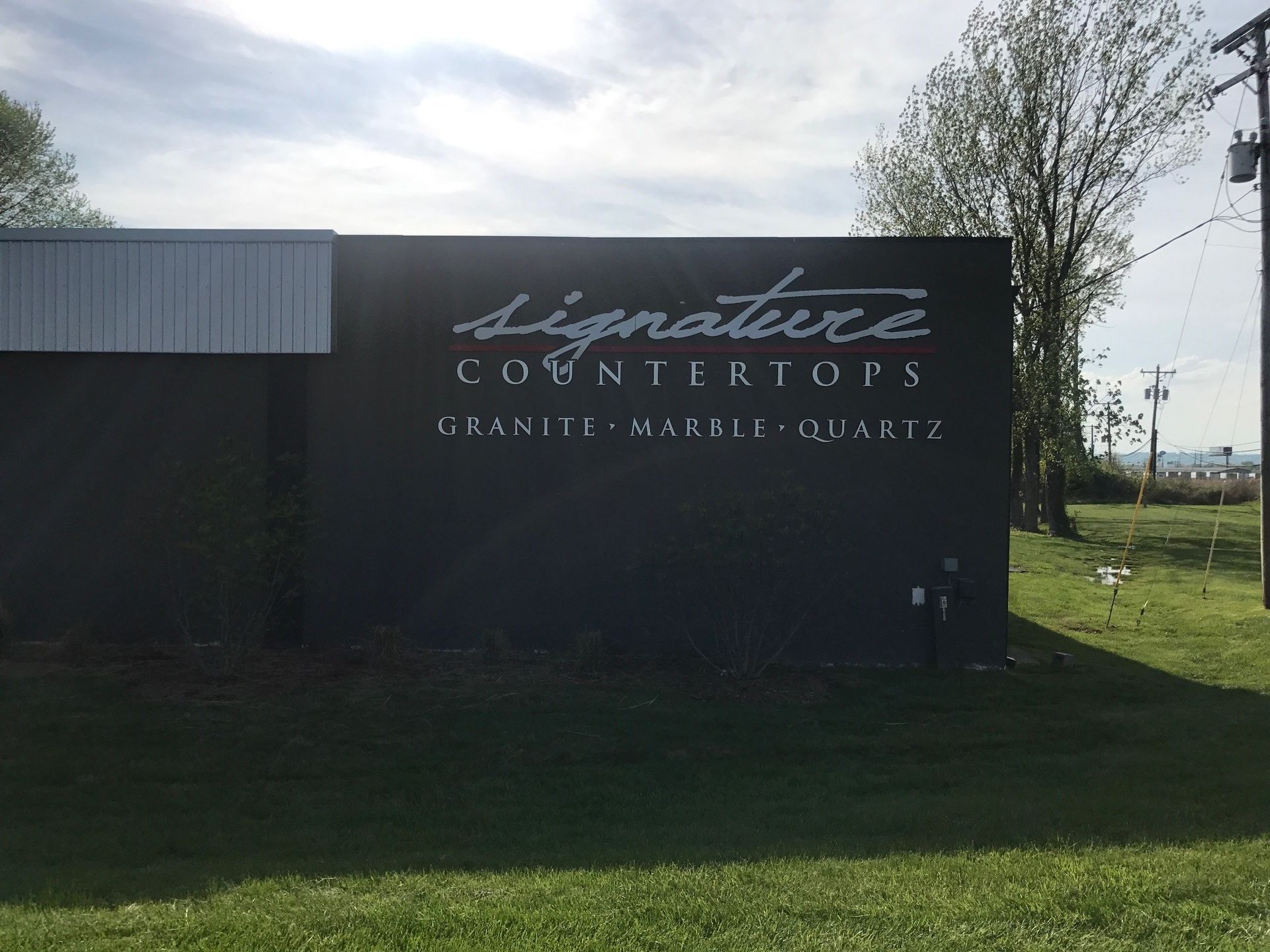 A black building with a sign that says signature countertops