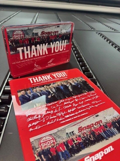 Two snap on thank you cards are on a conveyor belt