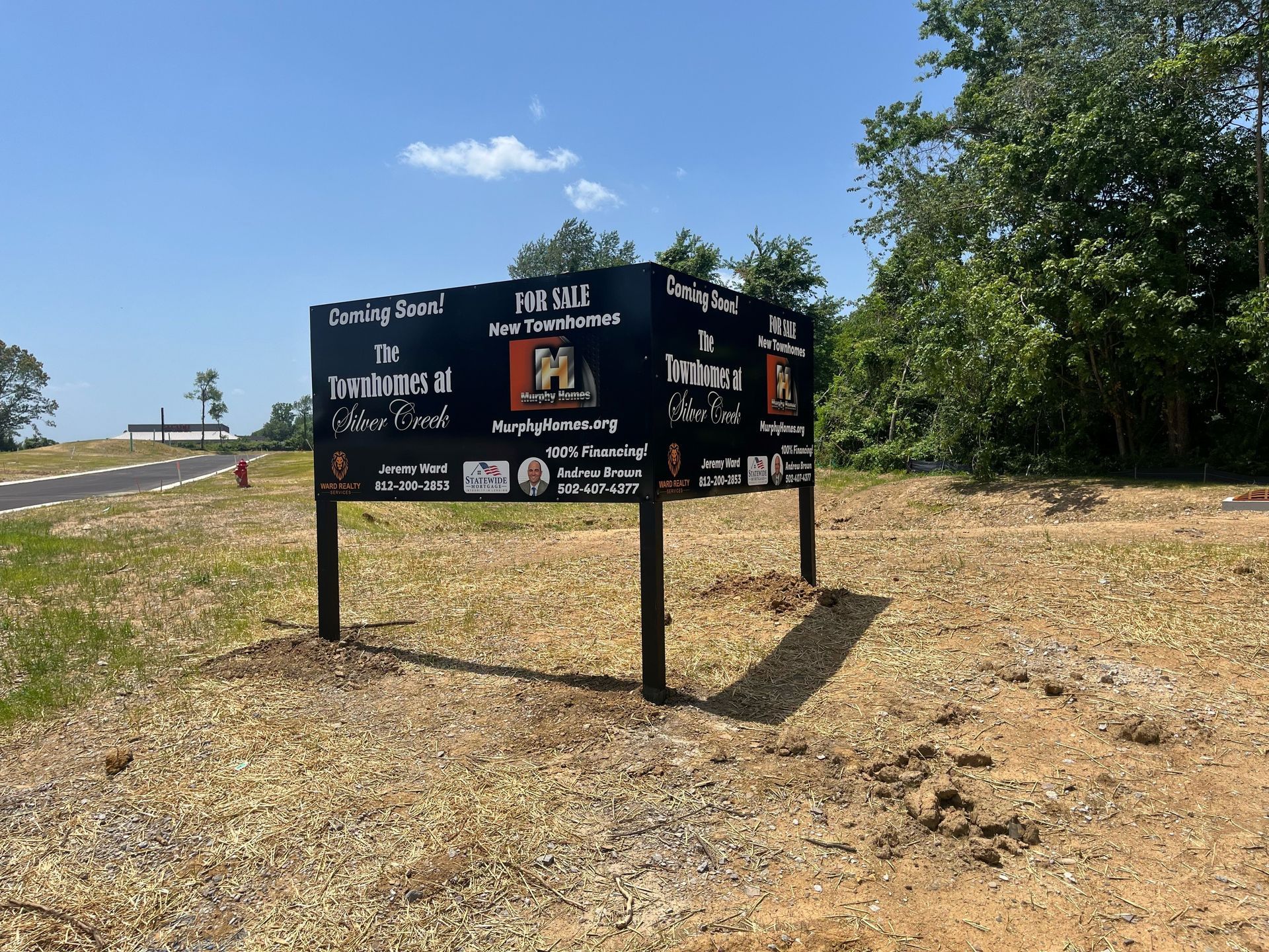 Two signs in a field with one that says ' coming soon ' on it