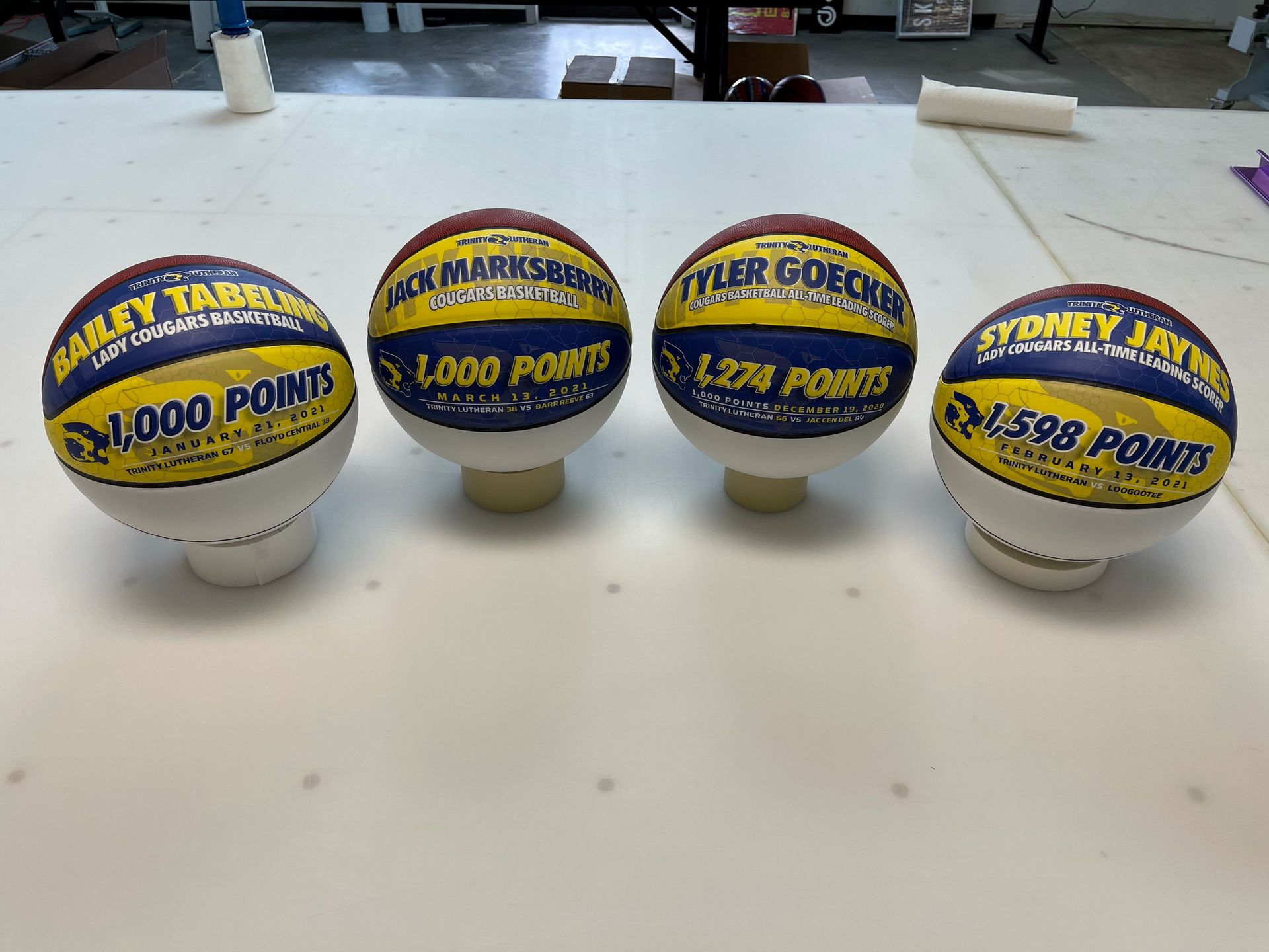 Four basketballs are sitting on top of each other on a table.