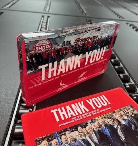 A thank you plaque is sitting next to a thank you card