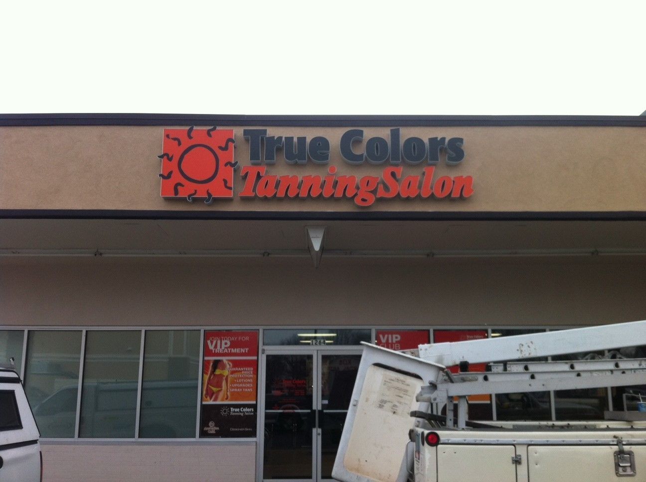 A tanning salon with a sign that says true colors tanning salon