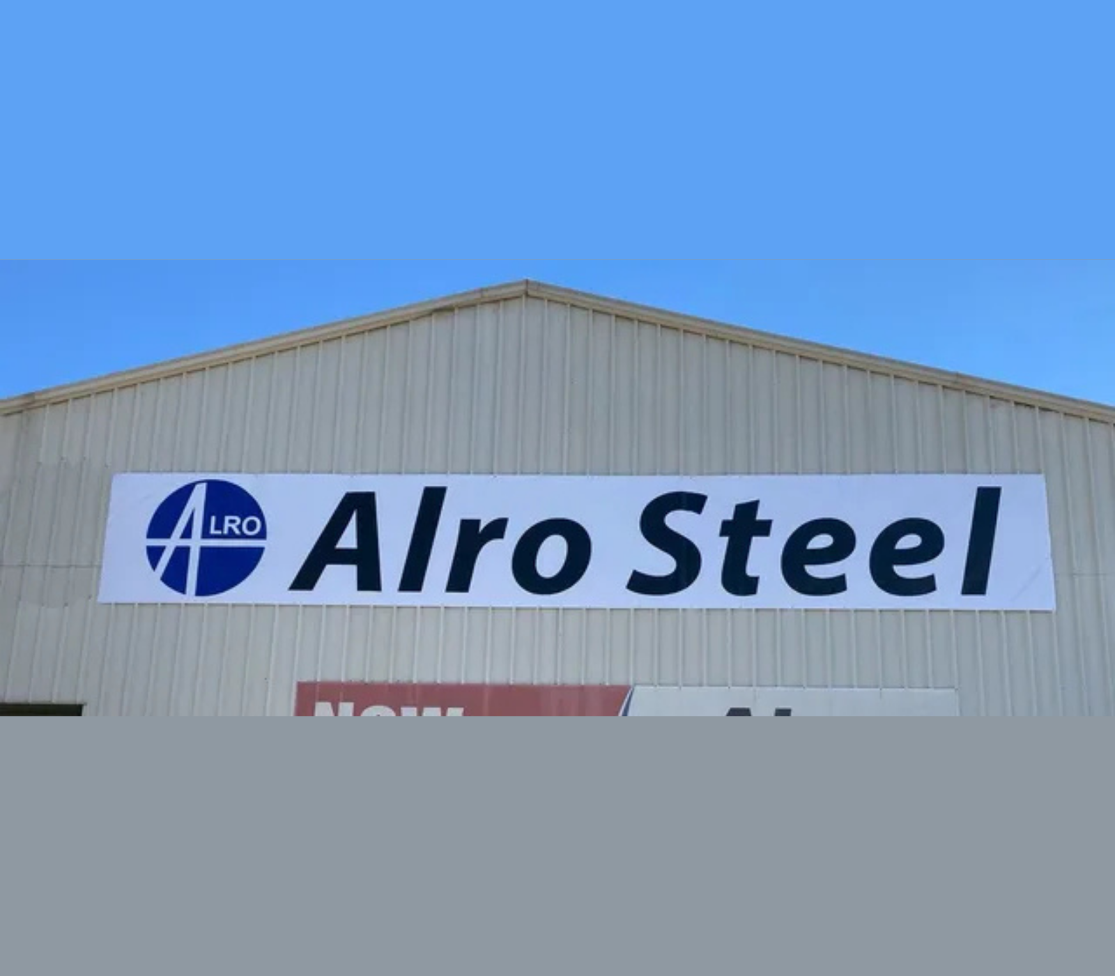 A large white sign on the side of a building says alro steel