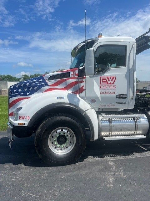 A white semi truck with the word estes on the side