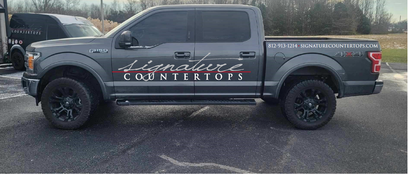 A gray pickup truck is parked in a parking lot.