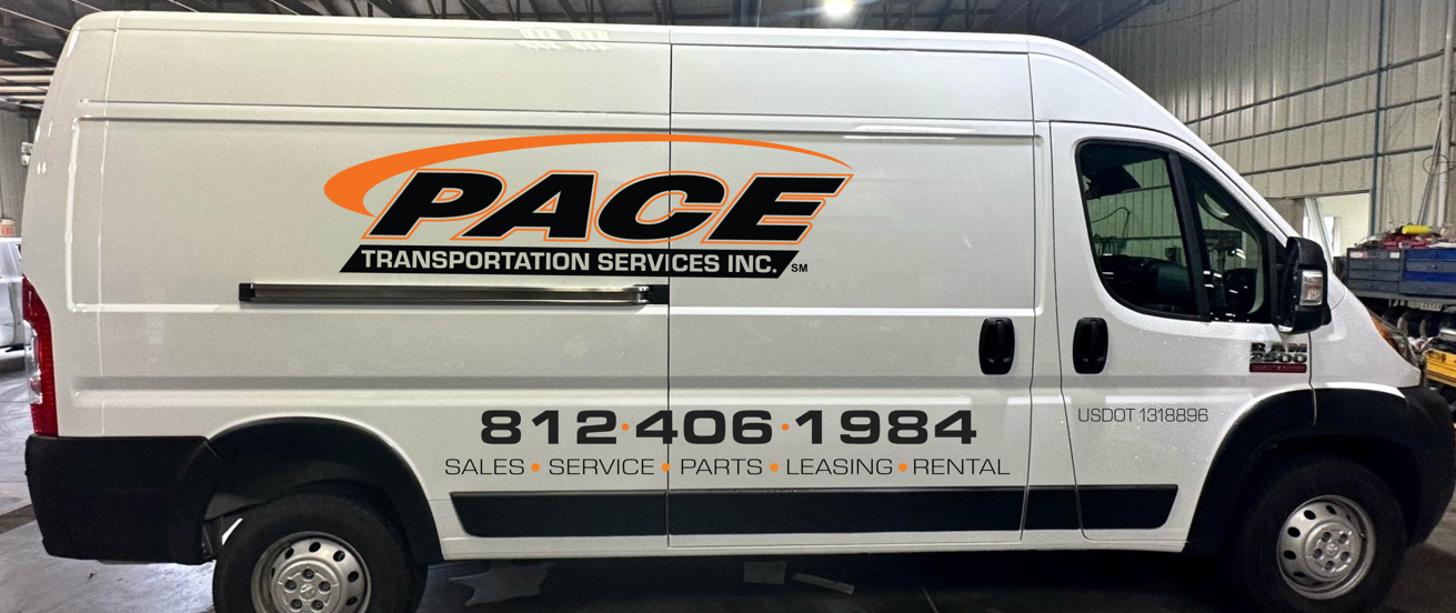 A white van with the word pace on the side is parked in a garage.