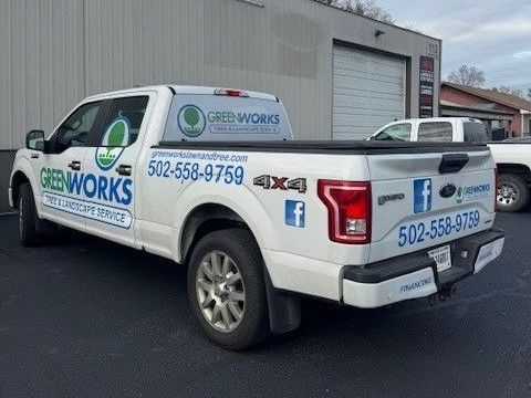 A white pickup truck is parked in front of a building.