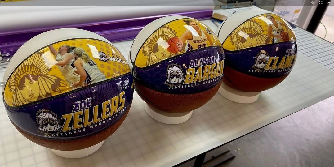 Three basketballs are sitting on top of each other on a table.