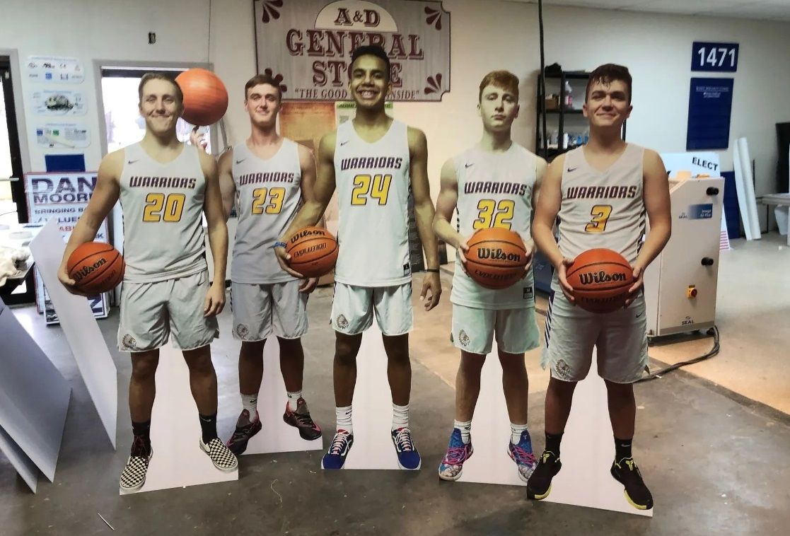 A group of basketball players standing next to each other holding basketballs