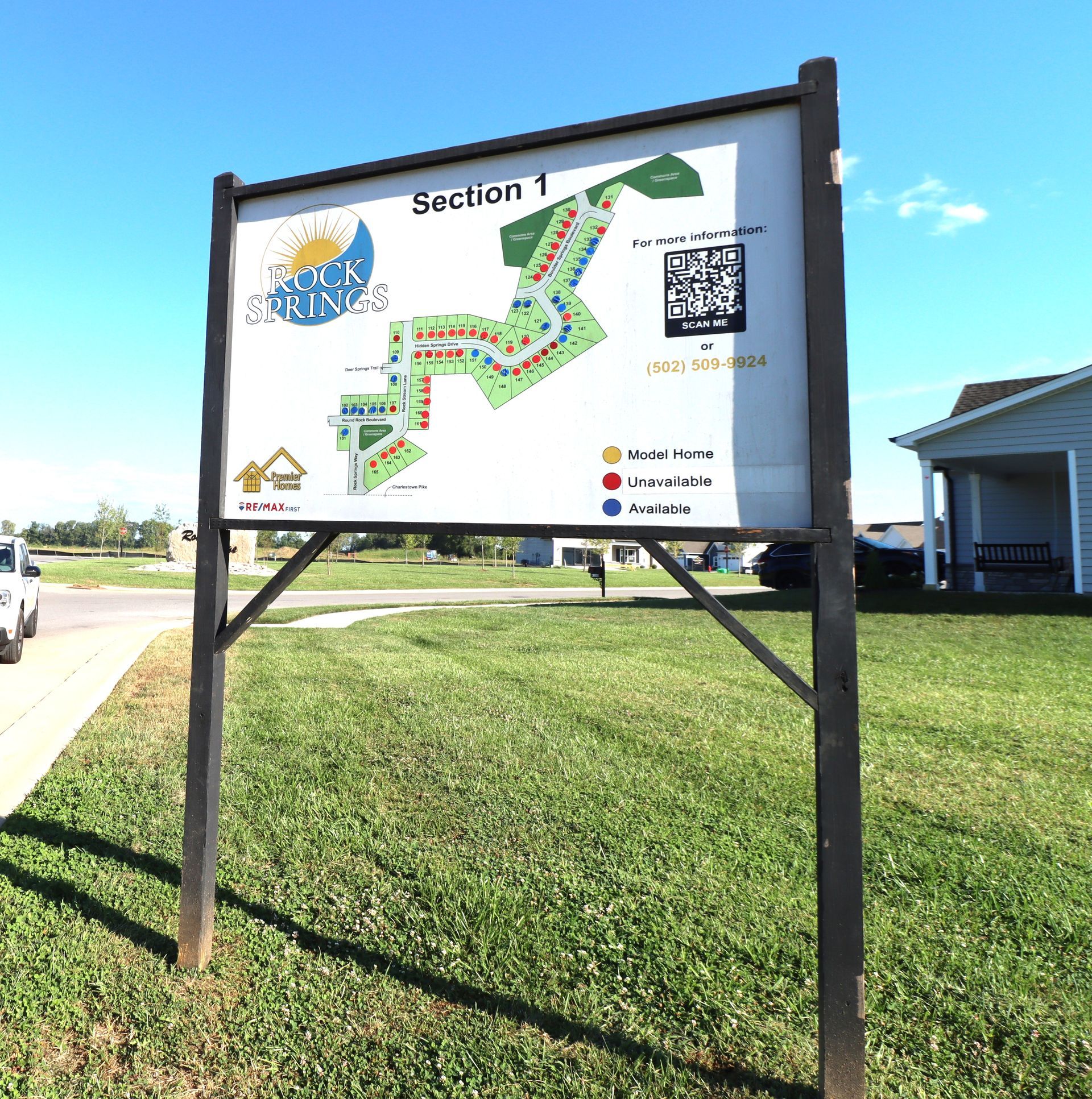 A map of the Rock Springs community Section 1 residential area displayed on a sign board in an outdoor grassy field.