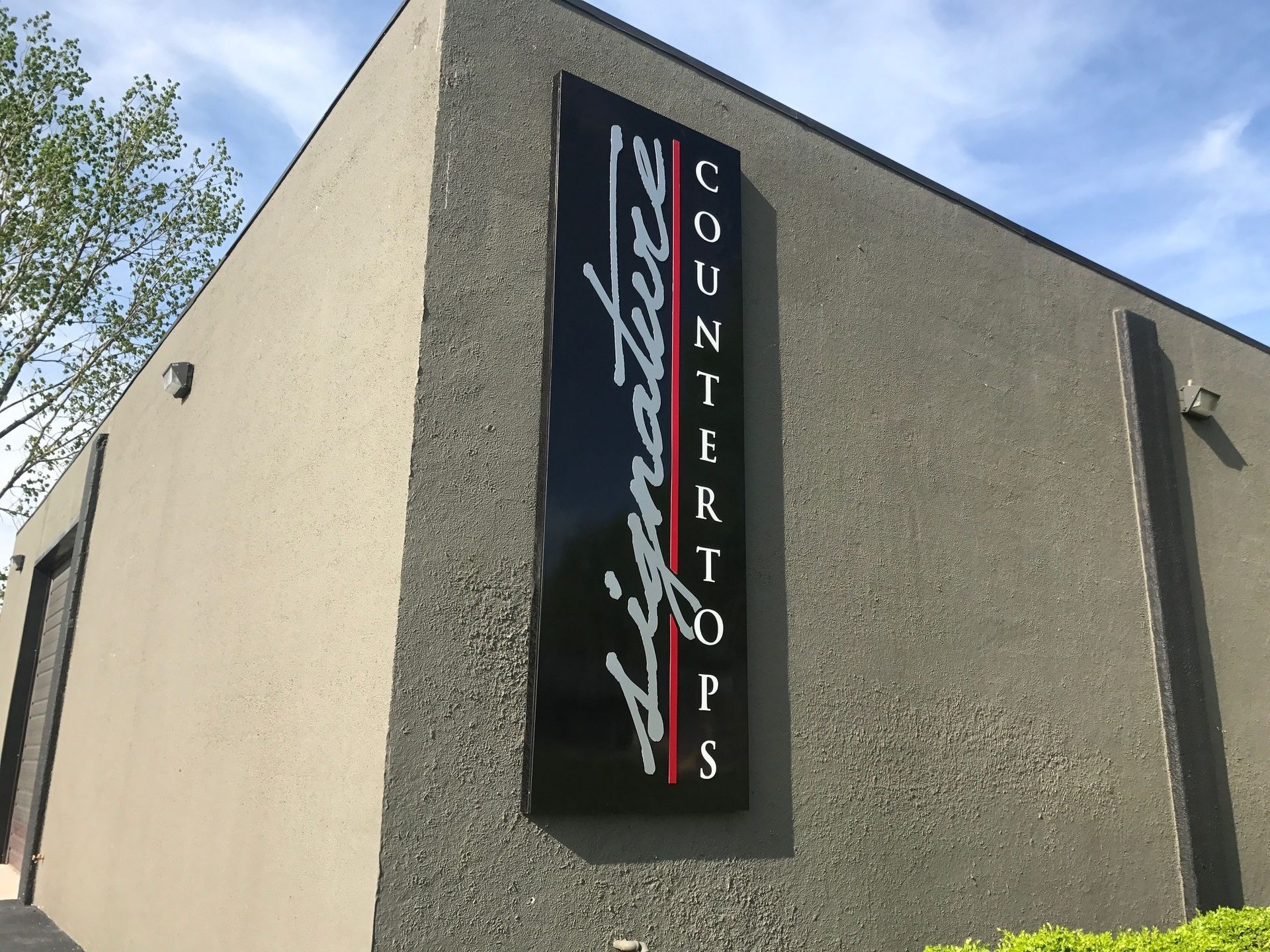 A sign on the side of a building that says signature countertops