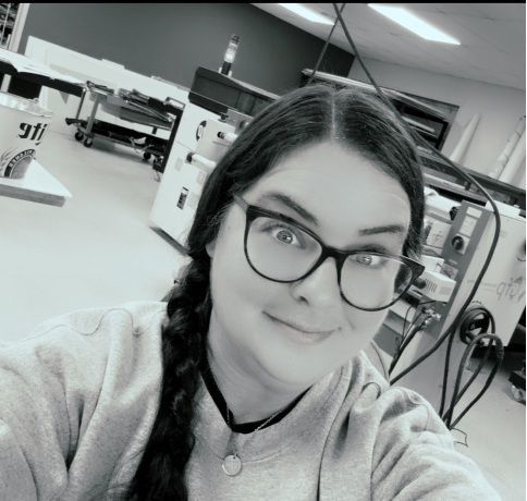 A woman wearing glasses is taking a selfie in a black and white photo.