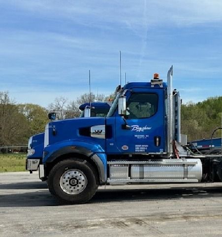 A blue semi truck is parked on the side of the road