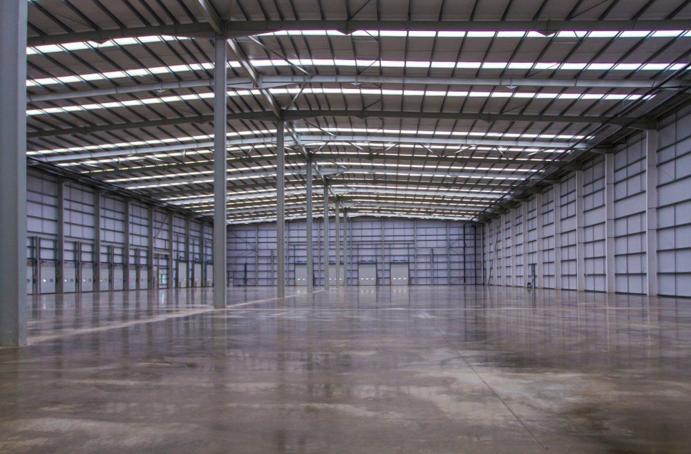 A Large Empty Warehouse With a Concrete Floor — C R Concreting in Warwick, QLD