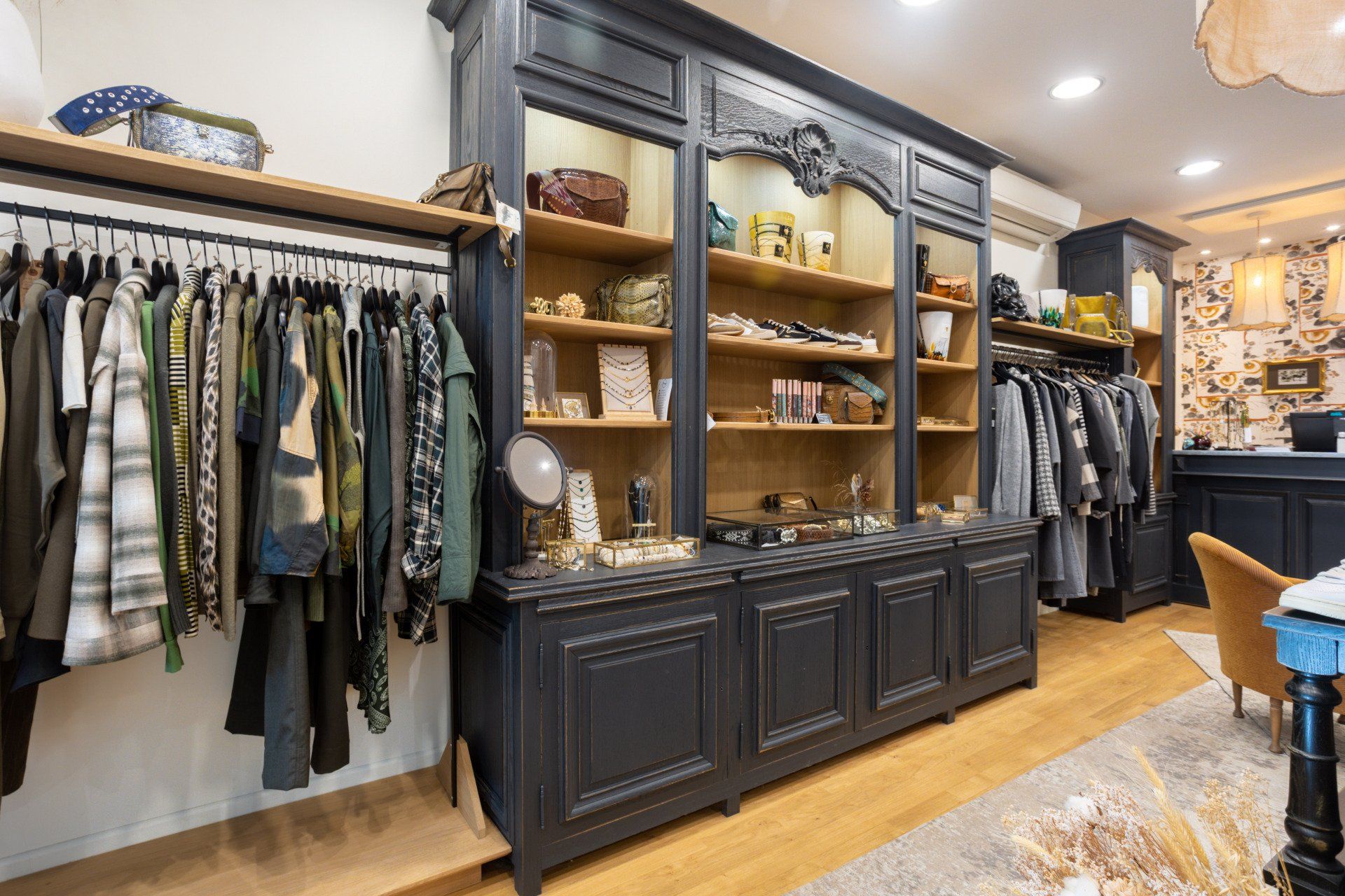 Un magasin de vêtements avec beaucoup de vêtements accrochés sur des portants et des étagères.