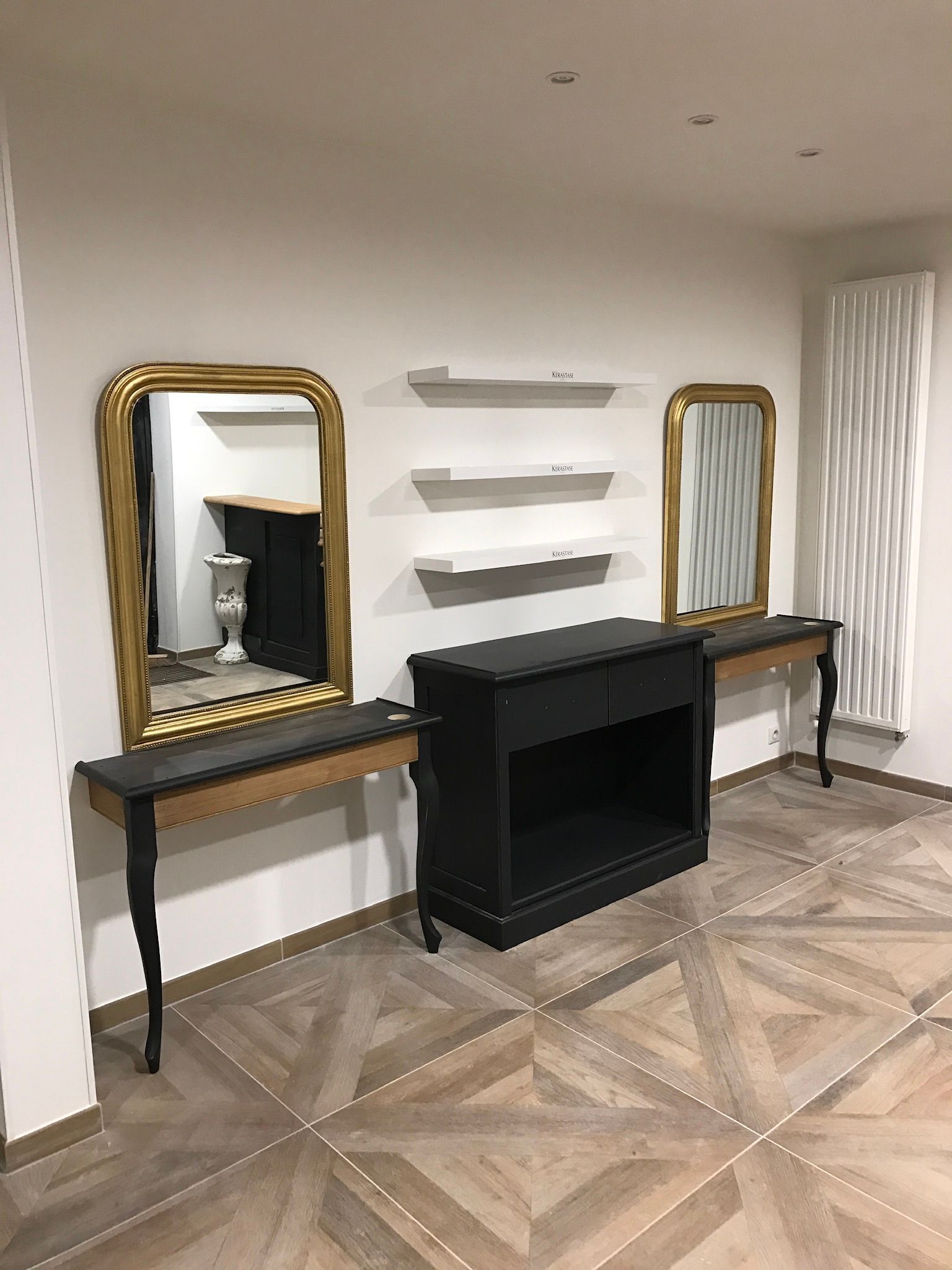 Un salon avec deux tables, deux miroirs et une cheminée.