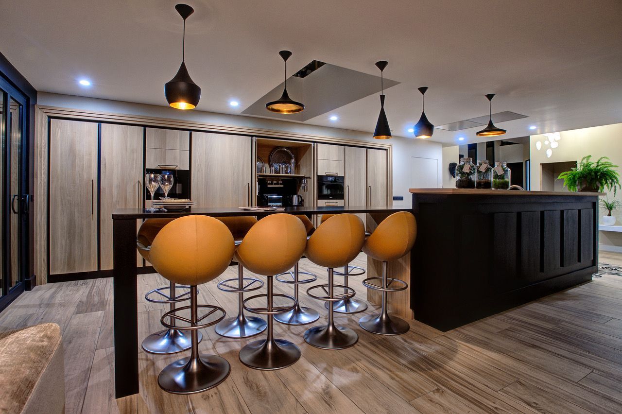 Une cuisine avec un bar et des tabourets