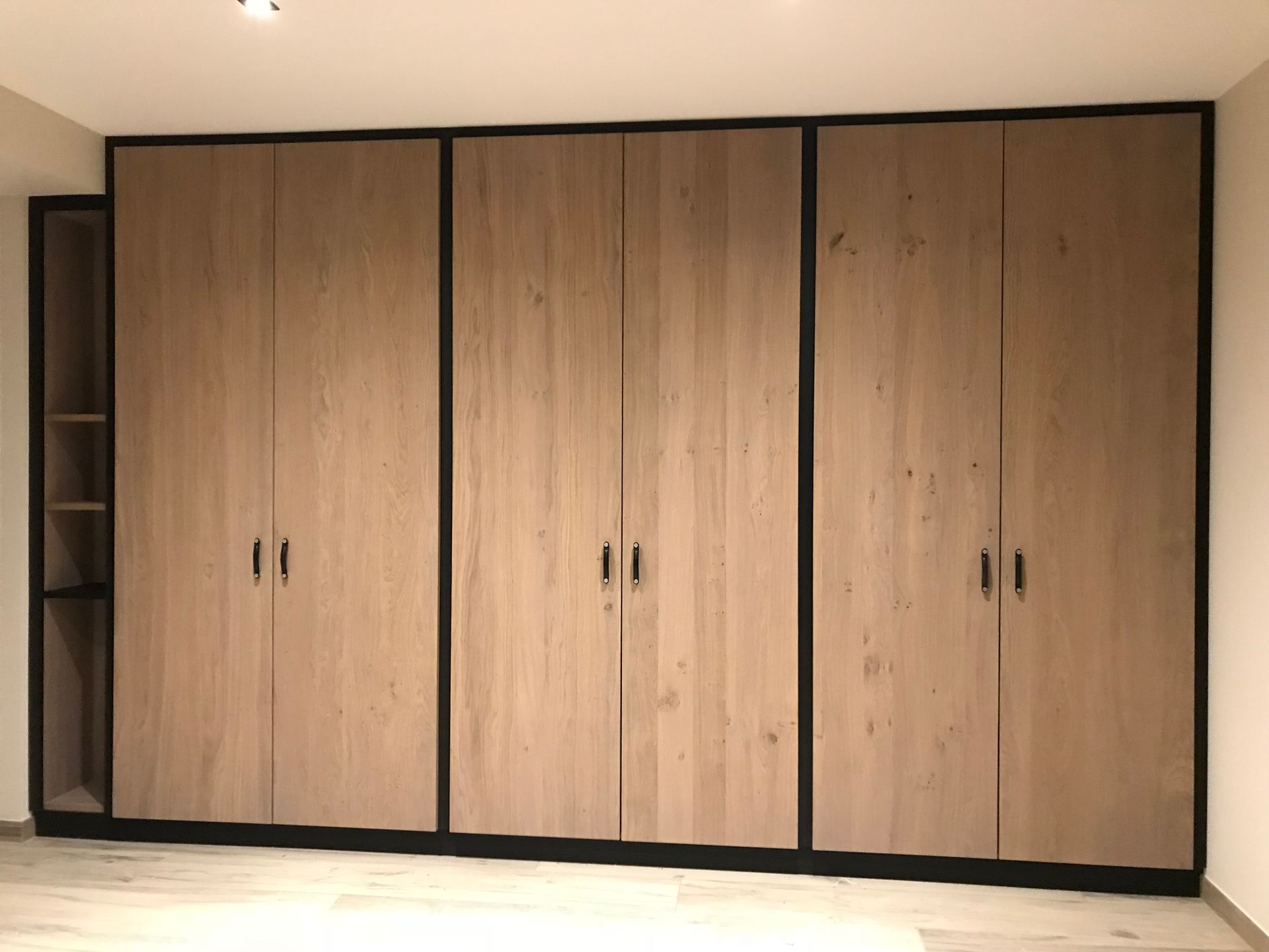 Une pièce avec beaucoup d'armoires et d'étagères en bois.