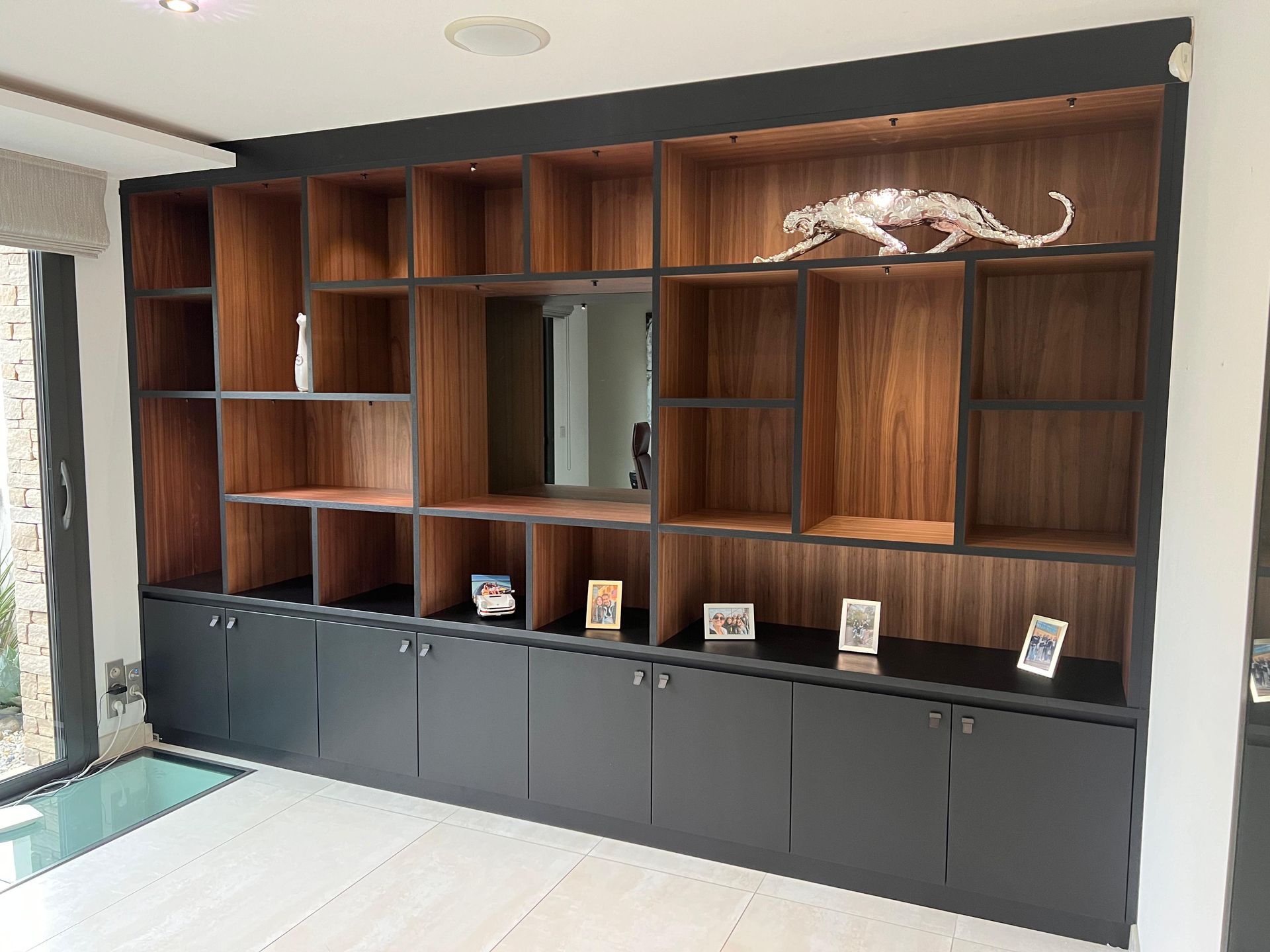 Il y a une statue d'un guépard au sommet d'une étagère en bois.