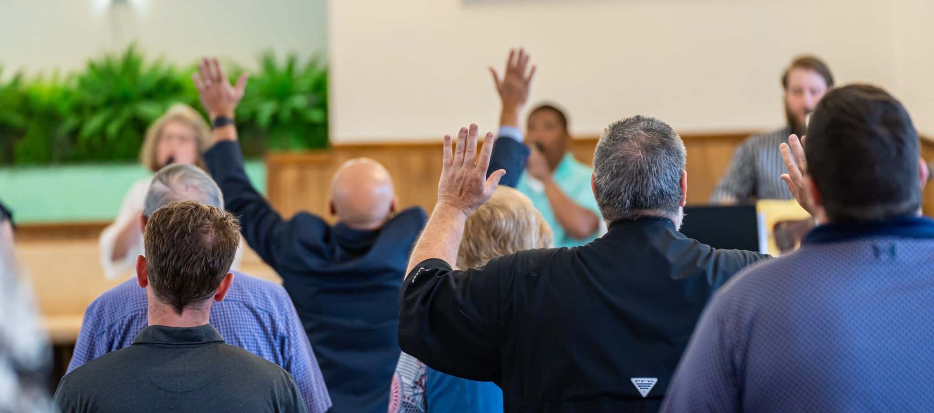 Armuchee Church of God -A group of people are raising their hands in the air in a room.