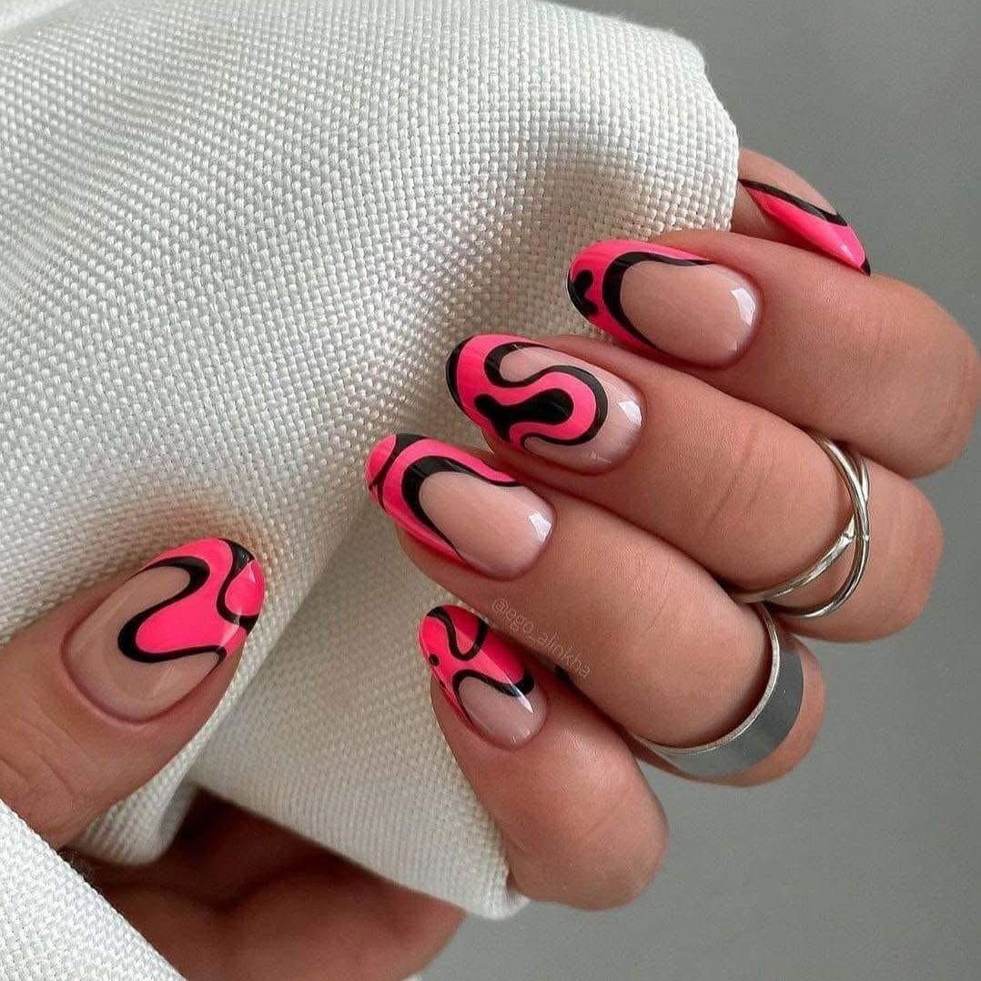 Un primer plano de las uñas de una persona con un diseño rosa y negro.