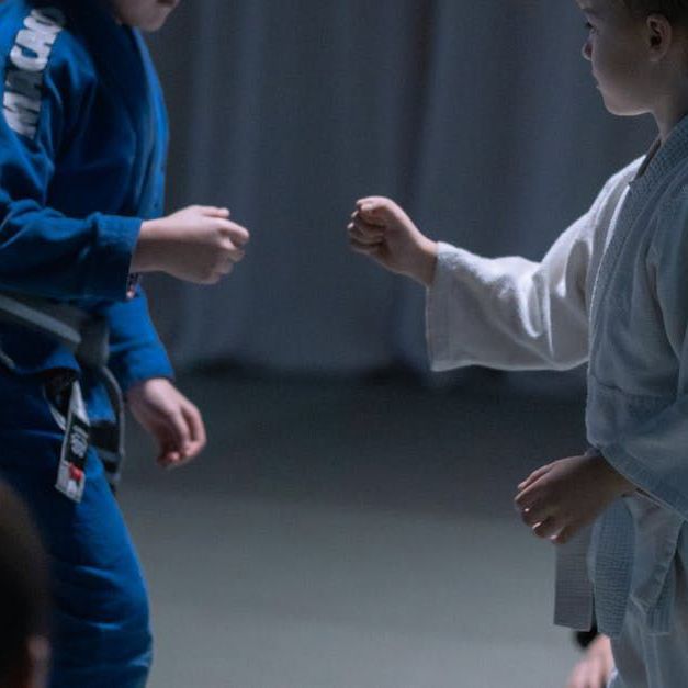 Two boys are standing next to each other in a dark room.