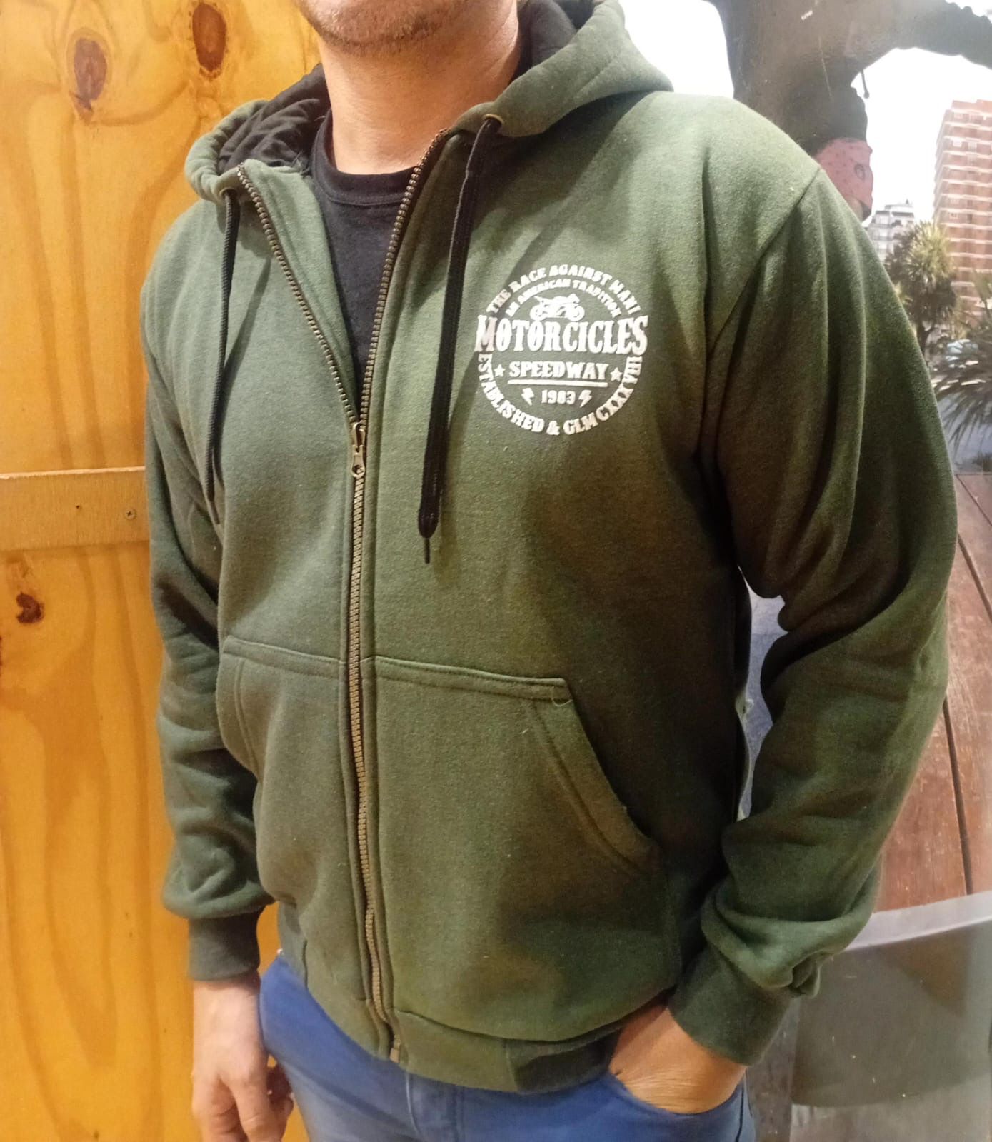 Un hombre que lleva una sudadera con capucha verde que dice motocicletas.