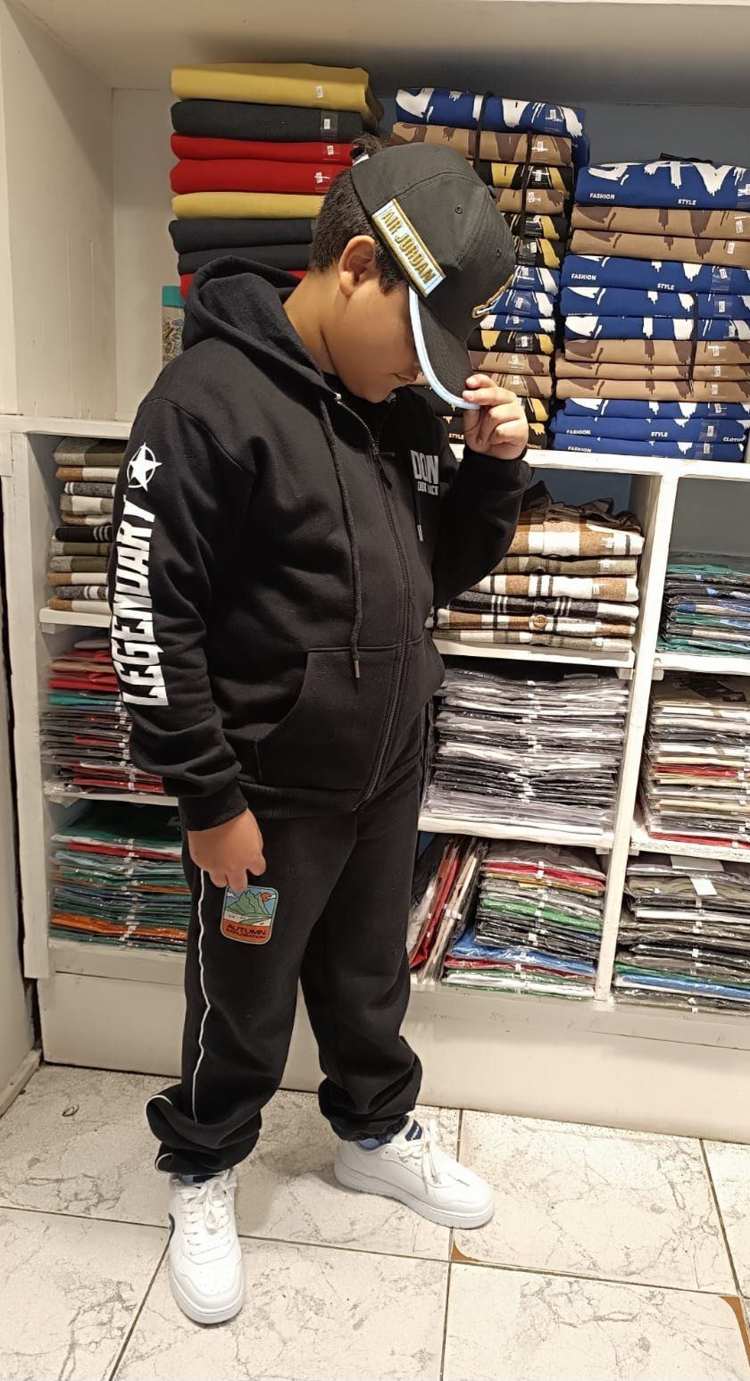 Un joven que lleva un sombrero y una sudadera con capucha está parado en una tienda.
