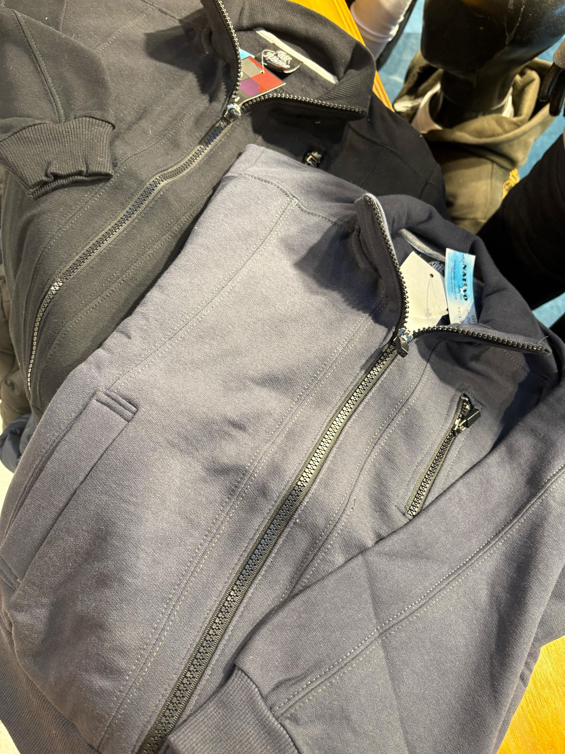 Maniquí con chaqueta gris y pantalón negro en una tienda de ropa.